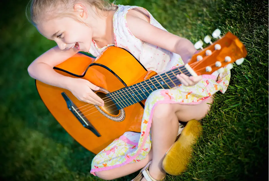 Girl playing guitar for Music lessons